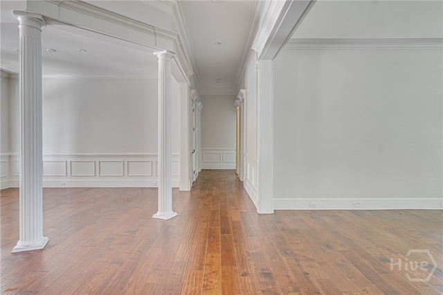 83 Waterway Dr, Savannah, GA 31411 - hallway with ornate columns, a decorative wall, wood finished floors, wainscoting, and crown molding