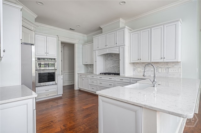 83 Waterway Dr, Savannah, GA 31411 - kitchen featuring appliances with stainless steel finishes, a peninsula, light stone counters, crown molding, and tasteful backsplash