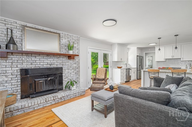 397 Hunt Dr, Savannah, GA 31406 - living room with light wood-type flooring, ornamental molding, french doors, and a brick fireplace