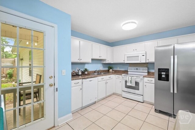 275 Carter St, Richmond Hill, GA 31324 - kitchen with white appliances, dark countertops, white cabinetry, and light tile patterned floors
