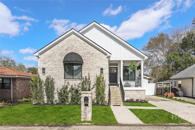 1212 Seiler Ave, Savannah, GA 31404 - view of front of house featuring board and batten siding, brick siding, covered porch, concrete driveway, and stairway