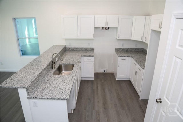 238 Millen St, Savannah, GA 31415 - kitchen with a peninsula, light stone counters, white cabinetry, and dark wood-style flooring