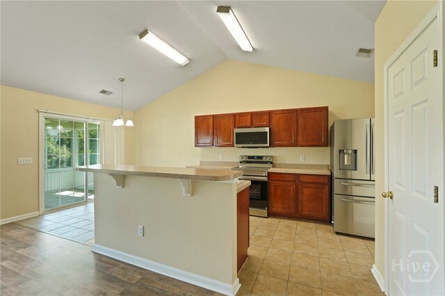 31 Cottingham Way, Pooler, GA 31322 - kitchen with appliances with stainless steel finishes, a kitchen bar, decorative light fixtures, light countertops, and a kitchen island