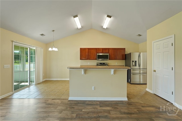 31 Cottingham Way, Pooler, GA 31322 - kitchen with stainless steel appliances, lofted ceiling, a kitchen bar, decorative light fixtures, and light countertops