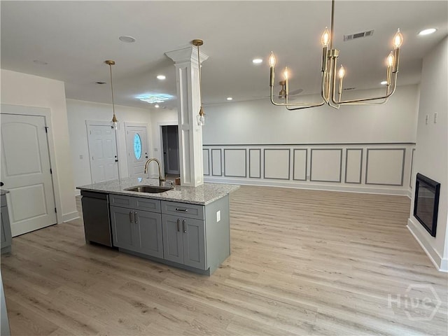 2310 Coakley St, Savannah, GA 31404 - kitchen with stainless steel dishwasher, gray cabinetry, open floor plan, light wood-style floors, and an island with sink