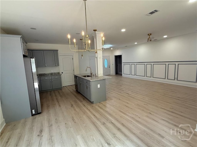 2310 Coakley St, Savannah, GA 31404 - kitchen featuring freestanding refrigerator, open floor plan, gray cabinets, light wood-type flooring, and a chandelier