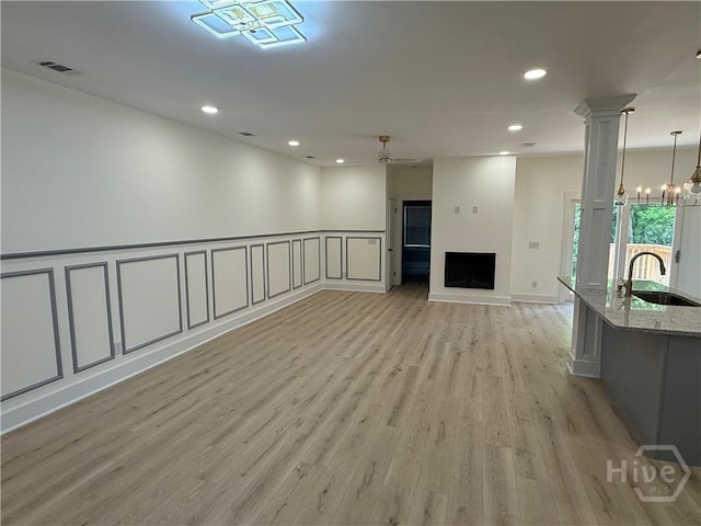 2310 Coakley St, Savannah, GA 31404 - unfurnished living room with a ceiling fan, light wood finished floors, recessed lighting, a fireplace, and a chandelier