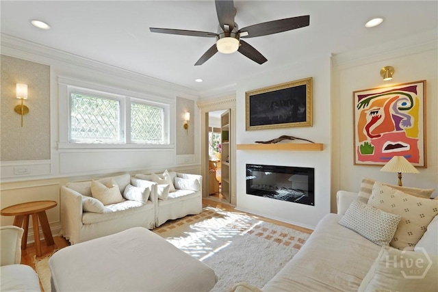 209 E 66th St, Savannah, GA 31405 - living room featuring crown molding, a glass covered fireplace, a decorative wall, ceiling fan, and wood finished floors