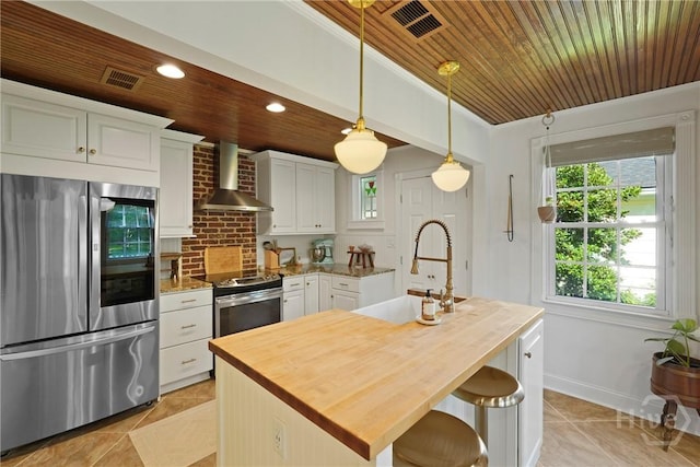 209 E 66th St, Savannah, GA 31405 - kitchen with appliances with stainless steel finishes, wall chimney range hood, wood counters, light tile patterned floors, and wood ceiling