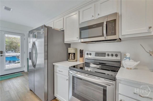 13 Izlar Ave, Tybee Island, GA 31328 - kitchen featuring appliances with stainless steel finishes, light countertops, white cabinetry, and light wood finished floors