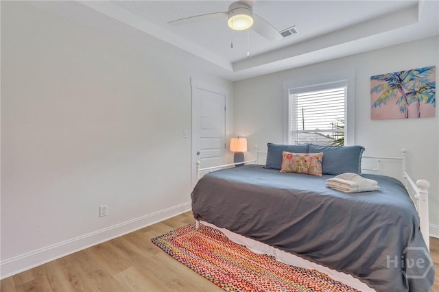 13 Izlar Ave, Tybee Island, GA 31328 - bedroom with a tray ceiling, light wood finished floors, and ceiling fan