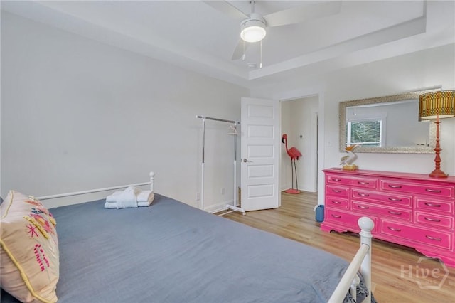 13 Izlar Ave, Tybee Island, GA 31328 - bedroom with wood finished floors, a raised ceiling, and a ceiling fan