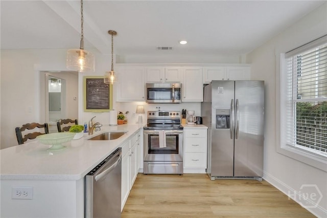 13 Izlar Ave, Tybee Island, GA 31328 - kitchen with appliances with stainless steel finishes, a peninsula, light countertops, white cabinetry, and recessed lighting