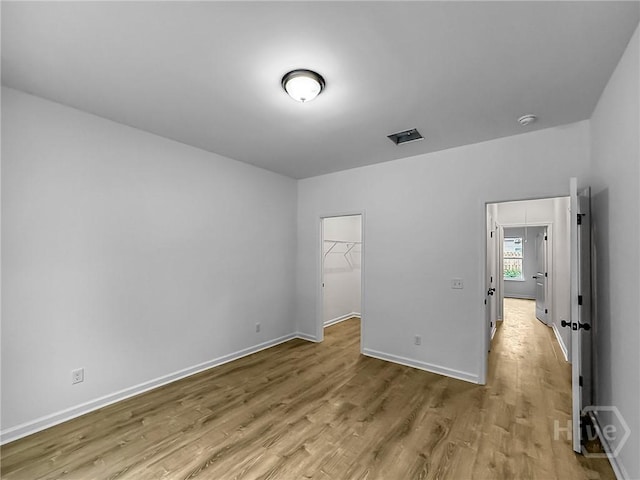 1031 Milton St, Savannah, GA 31405 - unfurnished bedroom featuring wood finished floors and a walk in closet