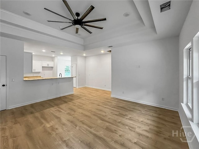 1031 Milton St, Savannah, GA 31405 - unfurnished living room featuring a tray ceiling, light wood finished floors, a ceiling fan, and recessed lighting
