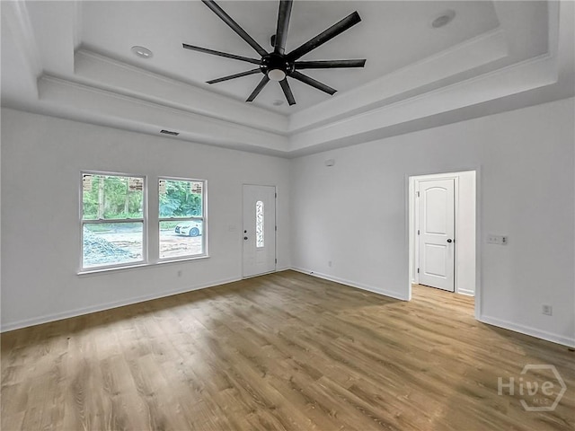 1031 Milton St, Savannah, GA 31405 - empty room featuring a tray ceiling, ceiling fan, wood finished floors, and ornamental molding