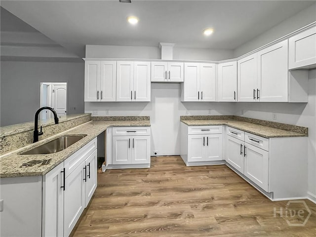 1031 Milton St, Savannah, GA 31405 - kitchen featuring light stone counters, white cabinets, a peninsula, light wood-type flooring, and recessed lighting