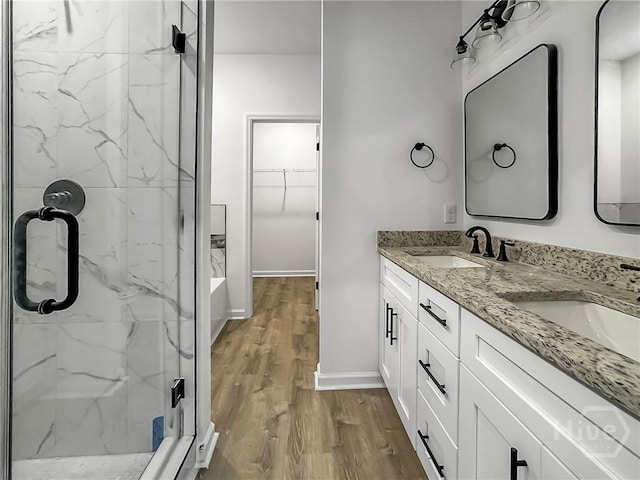 1031 Milton St, Savannah, GA 31405 - full bathroom with a marble finish shower, double vanity, wood finished floors, a spacious closet, and a tub