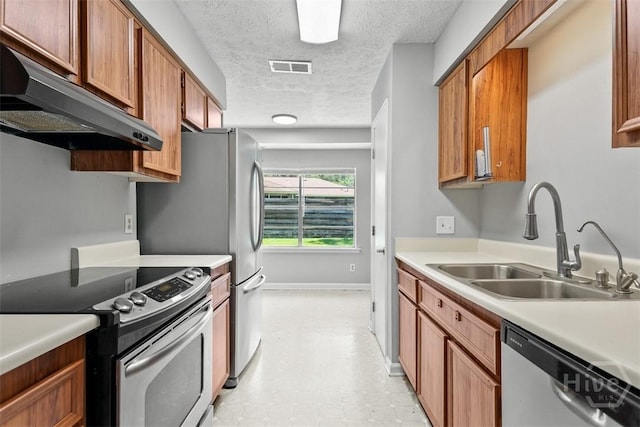 904 Mill Dr, Savannah, GA 31419 - kitchen featuring stainless steel appliances, under cabinet range hood, light countertops, a textured ceiling, and brown cabinetry