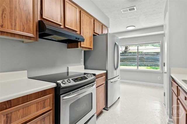 904 Mill Dr, Savannah, GA 31419 - kitchen with appliances with stainless steel finishes, under cabinet range hood, light countertops, brown cabinetry, and a textured ceiling