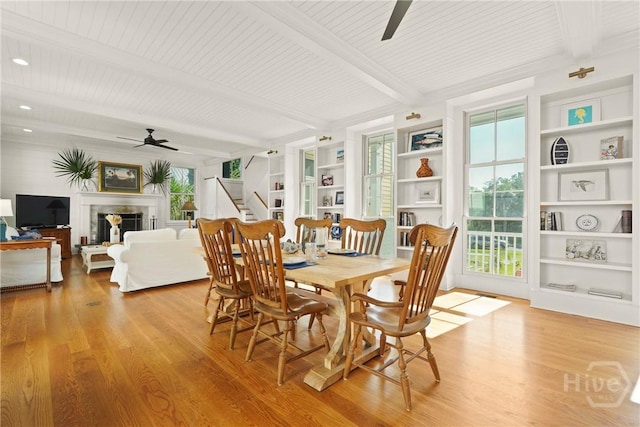 3 Palmwood Ct, Tybee Island, GA 31328 - dining space featuring a ceiling fan, wood finished floors, a fireplace, stairway, and a wooden ceiling with exposed beams