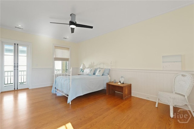 3 Palmwood Ct, Tybee Island, GA 31328 - bedroom featuring a wainscoted wall, light wood-style floors, and ceiling fan