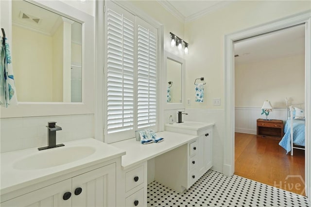 3 Palmwood Ct, Tybee Island, GA 31328 - ensuite bathroom featuring a wainscoted wall, ornamental molding, and two vanities