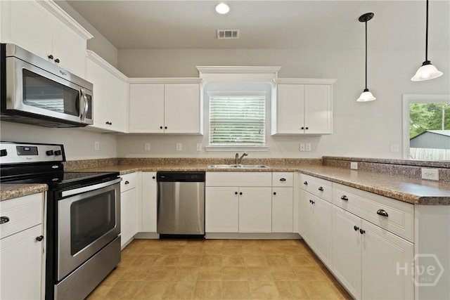 153 Whirlwind Way, Guyton, GA 31312 - kitchen with appliances with stainless steel finishes, a peninsula, white cabinets, and pendant lighting