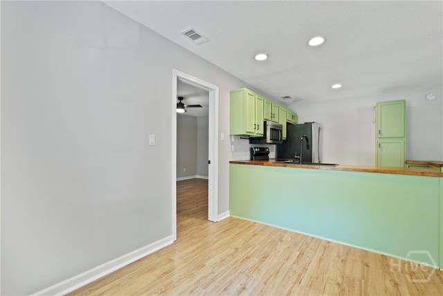 7305 Leghorn St, Savannah, GA 31406 - kitchen with green cabinetry, stainless steel microwave, light wood finished floors, freestanding refrigerator, and recessed lighting