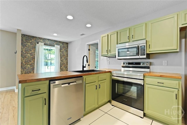 7305 Leghorn St, Savannah, GA 31406 - kitchen featuring appliances with stainless steel finishes, green cabinetry, wood counters, recessed lighting, and a textured ceiling