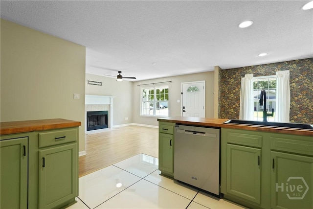 7305 Leghorn St, Savannah, GA 31406 - kitchen with green cabinets, stainless steel dishwasher, wooden counters, a high end fireplace, and a ceiling fan