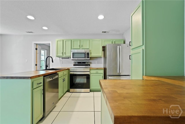 7305 Leghorn St, Savannah, GA 31406 - kitchen featuring green cabinets, appliances with stainless steel finishes, a peninsula, wooden counters, and recessed lighting