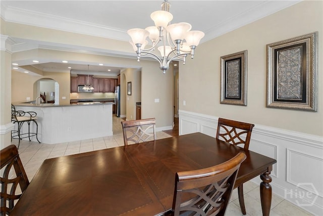 903 River Oaks Dr Unit 903, Richmond Hill, GA 31324 - dining room featuring light tile patterned flooring, arched walkways, crown molding, a chandelier, and a decorative wall
