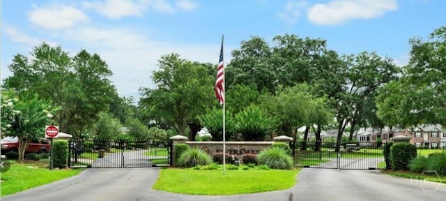 903 River Oaks Dr Unit 903, Richmond Hill, GA 31324 - view of asphalt street with a gate, traffic signs, and a gated entry