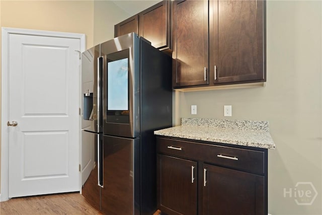 7 Saddle St N, Savannah, GA 31407 - kitchen featuring stainless steel fridge with ice dispenser, dark brown cabinets, light wood-style floors, and light stone counters