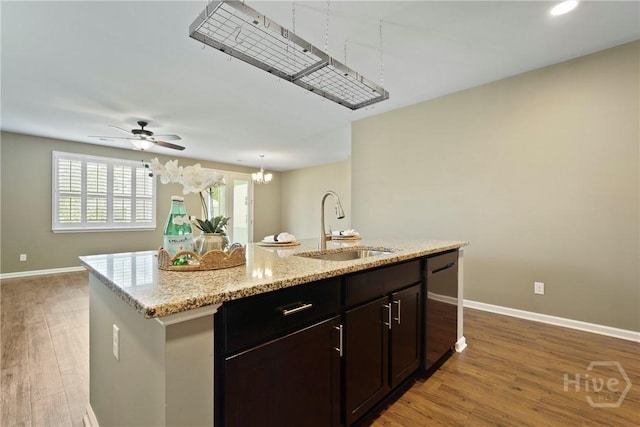 7 Saddle St N, Savannah, GA 31407 - kitchen featuring dishwashing machine, light wood-style floors, a kitchen island with sink, light stone counters, and recessed lighting
