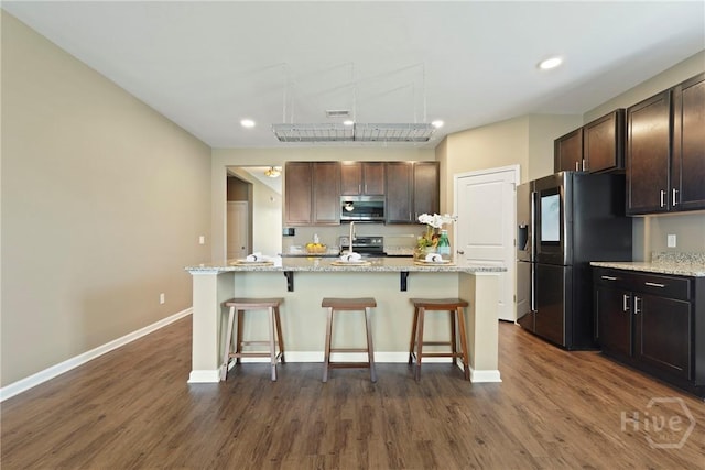 7 Saddle St N, Savannah, GA 31407 - kitchen with stainless steel microwave, fridge with ice dispenser, electric stove, a kitchen breakfast bar, and dark wood finished floors