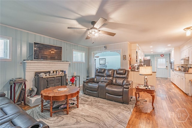 124 Drennon Dr, Jesup, GA 31545 - living room featuring crown molding, light wood-style flooring, a ceiling fan, and a fireplace
