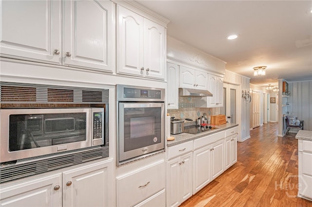 124 Drennon Dr, Jesup, GA 31545 - kitchen featuring appliances with stainless steel finishes, white cabinets, light wood-type flooring, decorative backsplash, and light countertops