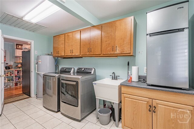 124 Drennon Dr, Jesup, GA 31545 - laundry room with water heater, cabinet space, independent washer and dryer, and light tile patterned flooring