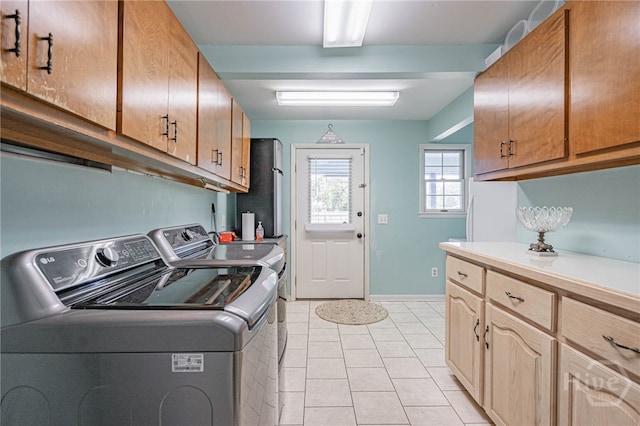 124 Drennon Dr, Jesup, GA 31545 - laundry room featuring washing machine and clothes dryer, cabinet space, and light tile patterned flooring