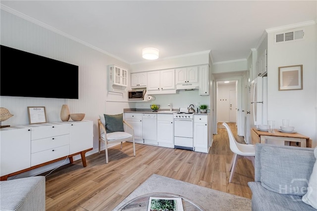 1217 Bay St Unit 109B, Tybee Island, GA 31328 - kitchen with white appliances, under cabinet range hood, ornamental molding, light wood finished floors, and white cabinetry