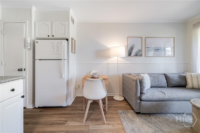 1217 Bay St Unit 109B, Tybee Island, GA 31328 - living area with light wood finished floors, crown molding, and wainscoting