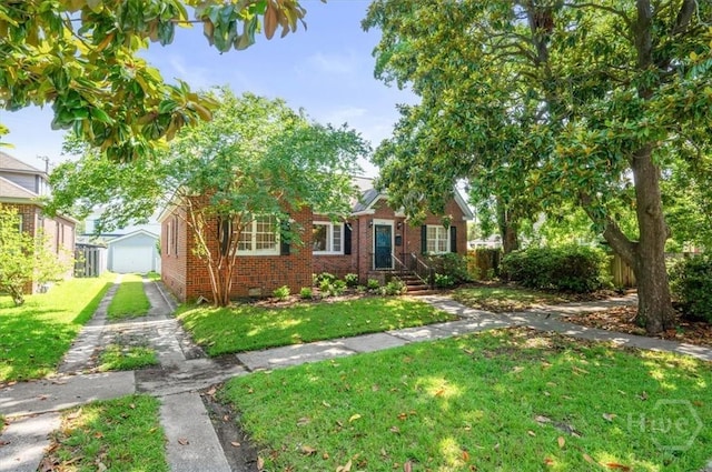308 E 55th St, Savannah, GA 31405 - view of front of home featuring brick siding, a front lawn, and an outbuilding