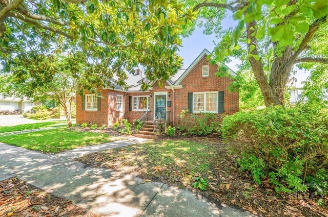 308 E 55th St, Savannah, GA 31405 - view of front facade featuring brick siding and a front lawn