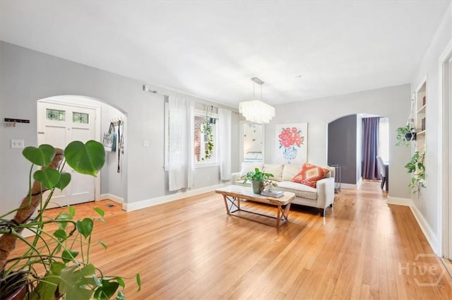 308 E 55th St, Savannah, GA 31405 - living area with arched walkways, light wood finished floors, and a chandelier