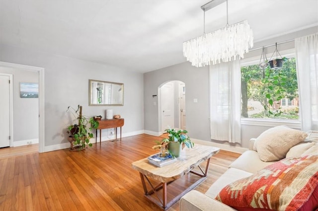 308 E 55th St, Savannah, GA 31405 - living room featuring arched walkways, light wood-type flooring, and a chandelier