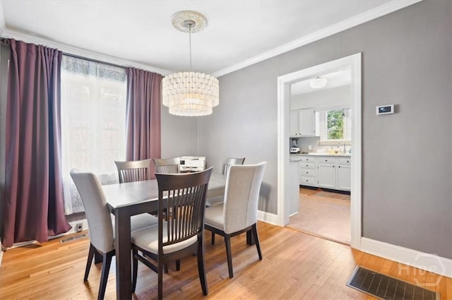 308 E 55th St, Savannah, GA 31405 - dining space with a chandelier, ornamental molding, and light wood-type flooring