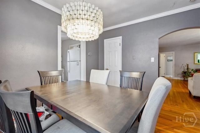 308 E 55th St, Savannah, GA 31405 - dining area featuring arched walkways, wood finished floors, crown molding, and a chandelier