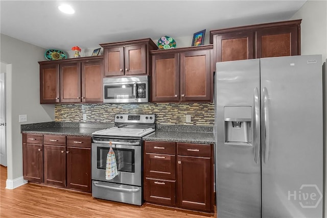 161 Laurel Ln, Guyton, GA 31312 - kitchen with stainless steel appliances, dark countertops, light wood-type flooring, and decorative backsplash